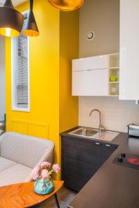 a kitchen with yellow walls and a table and a sink at Appartement 11 place d'Alliance in Nancy