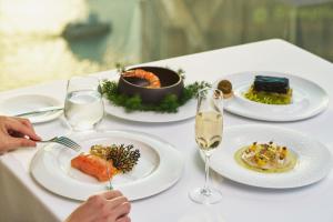 una mesa con platos de comida y copas de vino en Pudong Shangri-La, Shanghai, en Shanghái