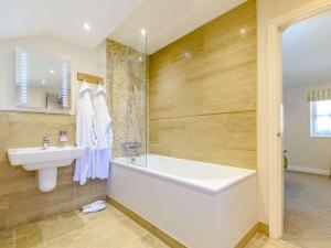 a bathroom with a sink and a bath tub and a sink at 5 Bed in Thirsk 40349 in Carthorpe