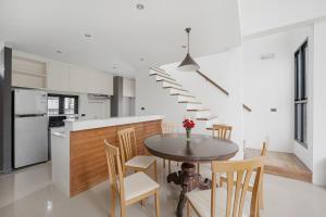 uma cozinha e sala de jantar com uma mesa e escadas em Ana's House em Nathon Bay