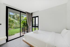 a bedroom with a white bed and a balcony at Ana's House in Amphoe Koksamui