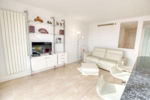 ein weißes Wohnzimmer mit einem Sofa und einem Tisch in der Unterkunft Le Clair Golfe-Juan - T2 terrasse vue mer Parking privé WIFI - LIMESTAY in Vallauris