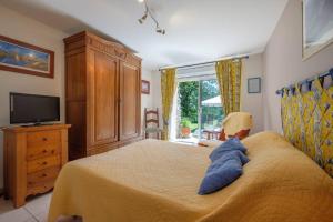 een slaapkamer met een bed, een televisie en een dressoir bij Domaine de Malouziès in Fontiers-Cabardès