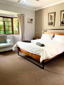 a bedroom with a large bed and a couch at The Croft cottage in Knysna