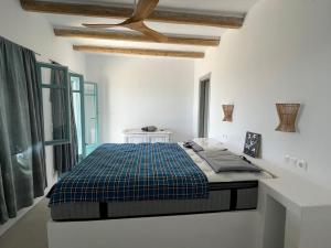 Posto letto in una camera bianca con soffitto di A Bedroom by the sea a Lisso (Lipsoi)