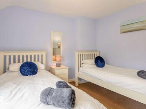 a bedroom with two beds with blue pillows on them at 4 Bed in Bakewell PK911 in Bakewell