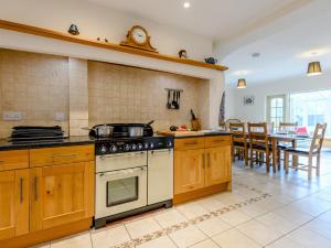 a kitchen with a stove and a dining room at 5 Bed in Godshill NFL35 in Godshill