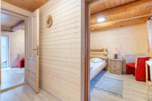 a room with a wooden wall with a small bedroom at Resort 7 Crai - Cabana Calinet in Zărneşti