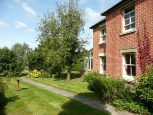 a red brick building with a tree in the yard at 5 Bed in Godshill NFL35 in Godshill