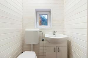 ein weißes Bad mit einem WC und einem Waschbecken in der Unterkunft Resort 7 Crai - Cabana Calinet in Zărneşti