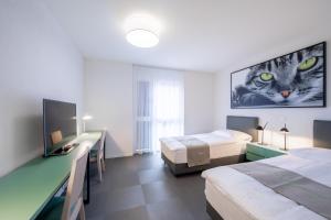 um quarto com duas camas e uma foto de gato na parede em "The Freddie Mercury" Hotel em Montreux