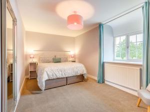 a bedroom with a bed and a window at 4 Bed in Umberleigh 50154 in Burrington