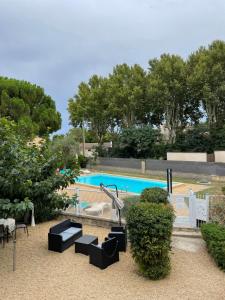 a view of a swimming pool with black furniture at Logis Hôtel Le Clement V in Roquemaure