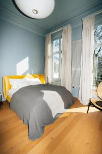 stilwerk Hotel Heimhude في هامبورغ: غرفة نوم مع سرير وبطانية رمادية