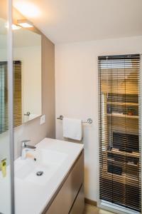 uma casa de banho com um lavatório branco e um espelho. em Appartement 11 place d'Alliance em Nancy