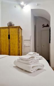 a pile of white towels sitting on top of a bed at Small & cozy near Piazza Navona in Rome