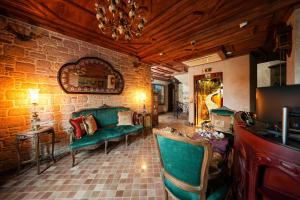 a living room with green chairs and a brick wall at Naz Su Cunda in Cunda