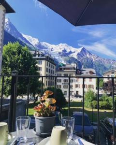 uma mesa com vista para as montanhas a partir de uma varanda em Hotel La Verticale em Chamonix-Mont-Blanc