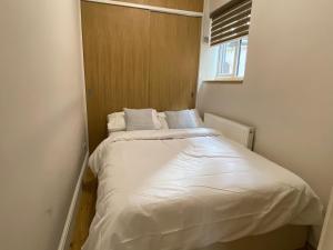 a small bedroom with a white bed in it at cheviot 2 bed in London