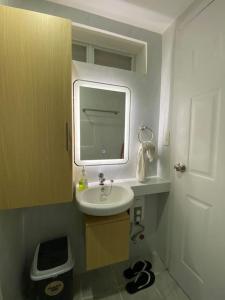 a small bathroom with a sink and a mirror at JC SpaceRentals 127B Amani Grand Resort Residences, balcony pool view, Ground floor, 5 mins frm airport, free wifi, Netflix in Pusok