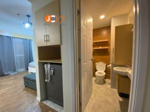 a small bathroom with a toilet and a sink at JC SpaceRentals 127B Amani Grand Resort Residences, balcony pool view, Ground floor, 5 mins frm airport, free wifi, Netflix in Pusok