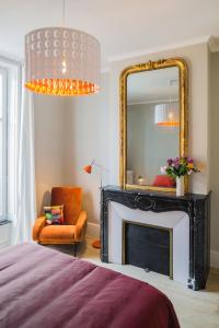 a bedroom with a fireplace and a mirror at Appartement 11 place d'Alliance in Nancy