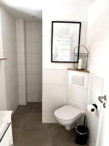 een badkamer met een toilet en een foto aan de muur bij Urlaub in unserem „kleinen Haus“ in Nindorf