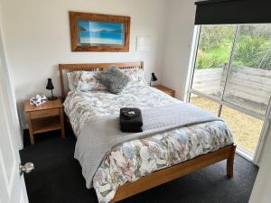um quarto com uma cama e uma janela em Tidal Dreaming Seaview Cottages em Yanakie