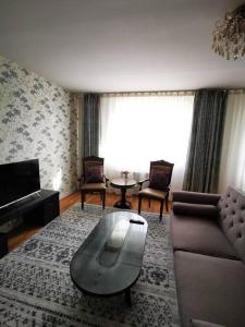a living room with a couch and a coffee table at Chic 2-Bedroom Apartment in 13th district in Ulaanbaatar