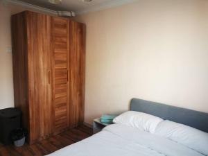 a bedroom with a bed and a wooden door at Chic 2-Bedroom Apartment in 13th district in Ulaanbaatar