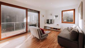 salon z kanapą i dużym oknem w obiekcie Nina´s Home w mieście Gablitz