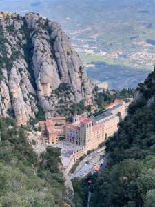 un edificio en una montaña junto a un acantilado en Casa acogedora al pie de Montserrat, en Collbató