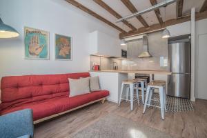 salon z czerwoną kanapą i kuchnią w obiekcie Born Sunny Apartment (self check-in) w Barcelonie