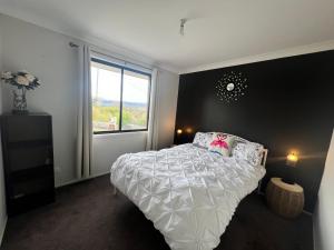 a bedroom with a white bed and a window at Hartley Valley Views in Hartley