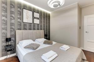 - une chambre avec un lit et 2 serviettes dans l'établissement Nadmorski Park Comfort Apartments, à Gdańsk
