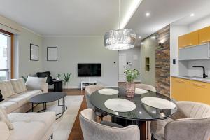 a living room with a table and chairs at Nadmorski Park Comfort Apartments in Gdańsk