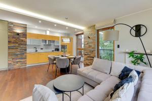 a living room with a couch and a table at Nadmorski Park Comfort Apartments in Gdańsk