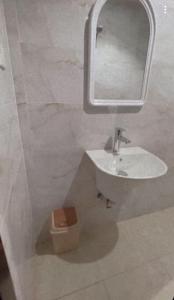 a bathroom with a sink and a mirror and a toilet at شقق السلام المخدومة in Al Madinah