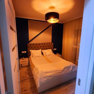 1 dormitorio con 1 cama grande con sábanas blancas en Apartament ASB Oradea, en Oradea