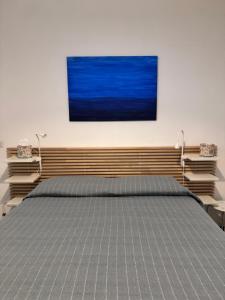 ナポリにあるRiviera Apartment Napoliのベッドルーム1室(青い絵画が壁に描かれたベッド1台付) +7枚の写真