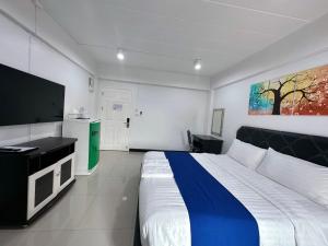 1 dormitorio con 1 cama grande y TV de pantalla plana en The Sceneสุพรรณบุรี, en Suphanburi