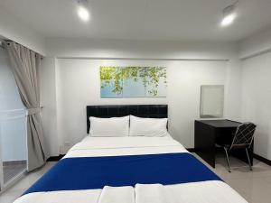 1 dormitorio con cama y escritorio. en The Sceneสุพรรณบุรี, en Suphanburi