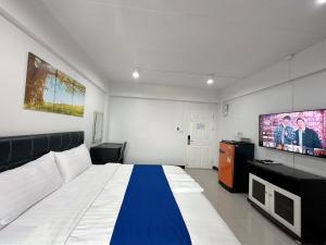 Schlafzimmer mit einem Bett und einem Flachbild-TV in der Unterkunft The Sceneสุพรรณบุรี in Suphan Buri
