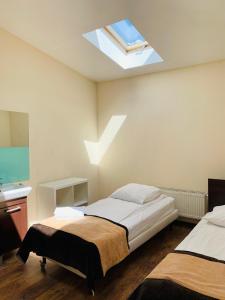 um quarto com 2 camas e uma clarabóia em Boutique Hostel em Lódź