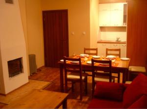 a dining room with a table and chairs and a kitchen at MD Alexander Services Apartments in Bansko