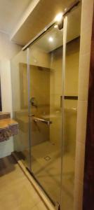 a glass shower door in a room with at Alam Indah Busuanga Beach and Villas in Busuanga