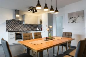 uma cozinha e sala de jantar com uma mesa de madeira e cadeiras em AlpenParks Residence Zell am See em Zell am See