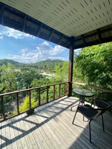 une terrasse en bois avec une table et des chaises dessus dans l'établissement Rocky resort, à Koh Tao