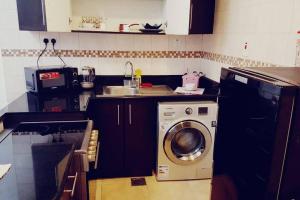 a kitchen with a washing machine and a sink at Studio Luxury Apartment by Mamzar Beach in Dubai