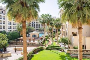 Studio Luxury Apartment by Mamzar Beach في دبي: ساحة مع نخيل في مبنى